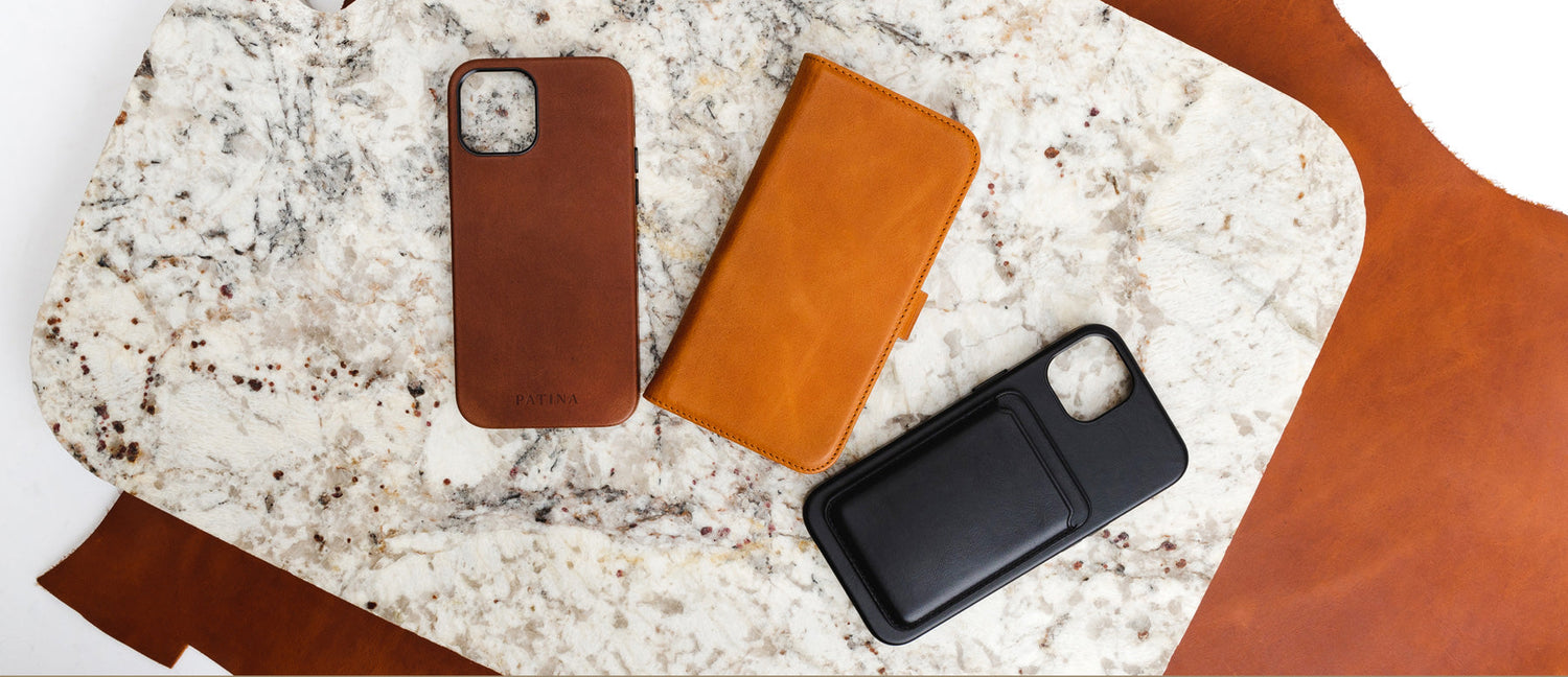 3 iPhone leather cases on a marble slab with leather hide