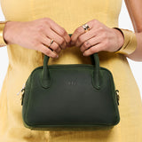 Evergreen Small | A bowler styled bag being held by a model in a yellow dress