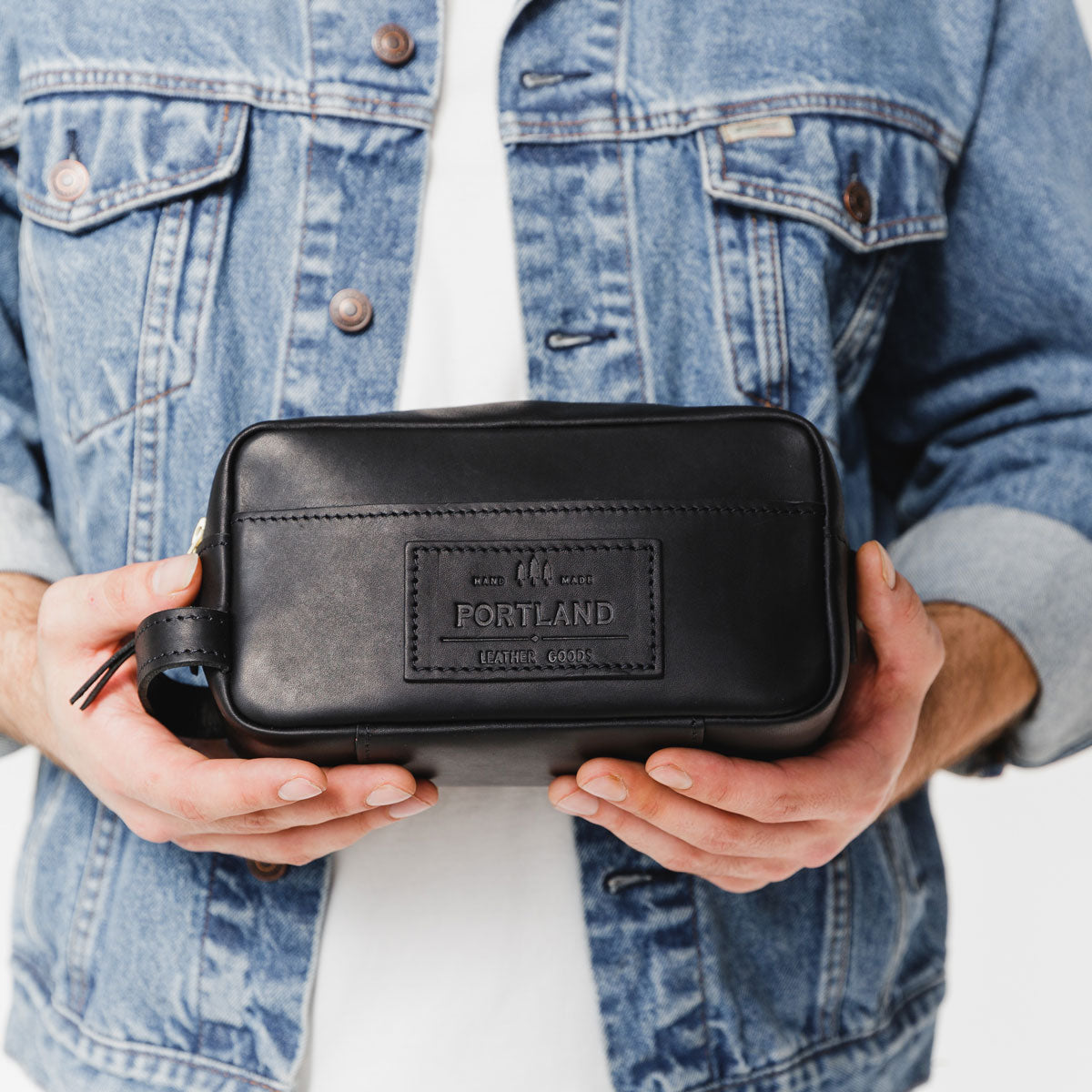 Black | Model holding large rectangular leather dopp kit
