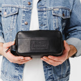 Black | Model holding large rectangular leather dopp kit