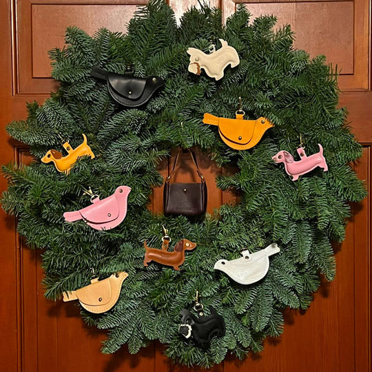 Decorative wreath with colorful animal-shaped ornaments on a wooden door