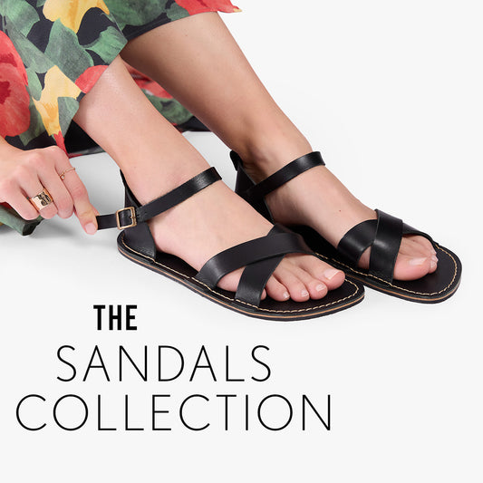 A person wearing black leather strappy flat sandals