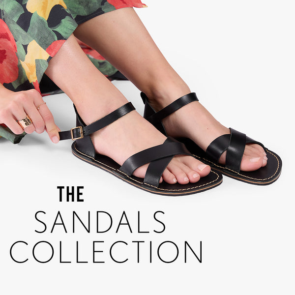 A person wearing black leather strappy flat sandals