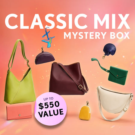 Promotional graphic for a 'Classic Mix Mystery Box' featuring a collection of Crossbodies, wallets, and small goods. Set against an orange sparkly background with a pink badge indicating up to $550 value.