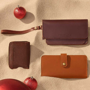 Group of leather wallets on sand