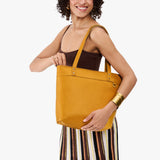 Sunshine Medium Zipper | Model wearing leather tote bag with riveted straps and exterior key loop