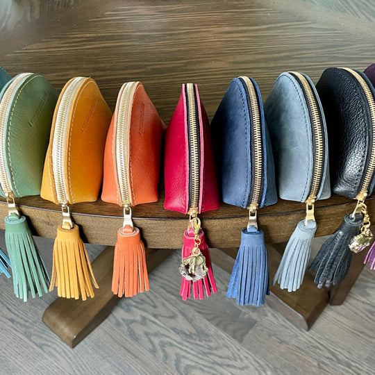 Row of colorful Taco Tassel Pouches on a wooden stand