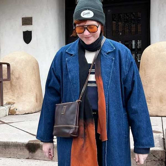 Woman wearing denim jacket and leather crossbody bag