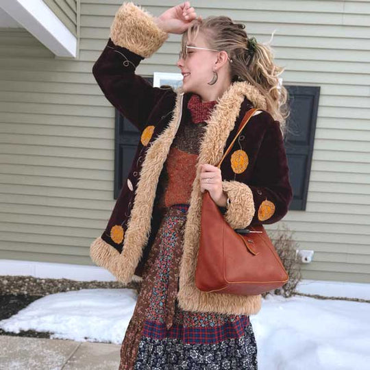 Woman wearing winter coat carrying a leather shoulder bag