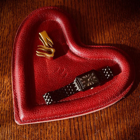 Chili Red Heart Trinket Tray with a watch on a wooden surface
