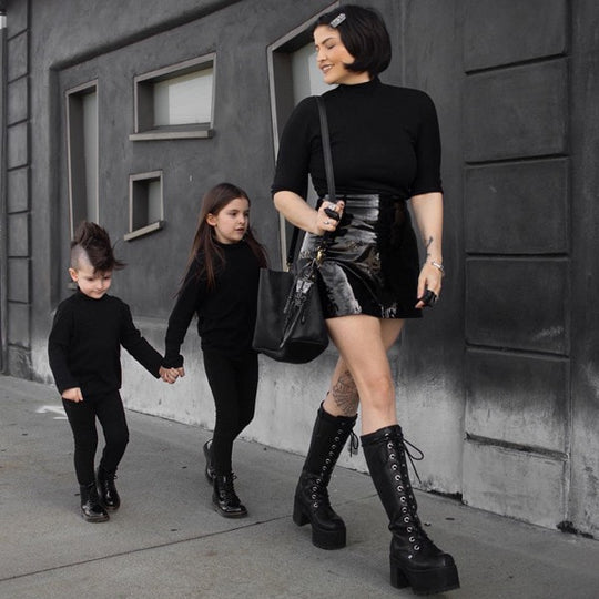 three people walking in all black outfits
