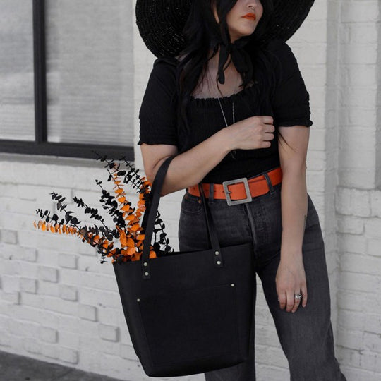person standing and holding a Classic Leather Tote Bag