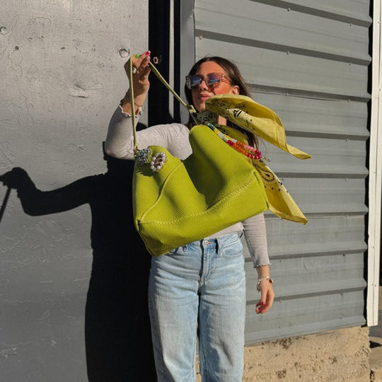 A person holding a lime green bag