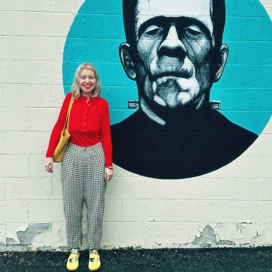 A person standing in front of a frankenstein mural