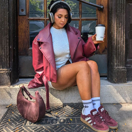 Person outside sitting next to Nora Shoulder Bag