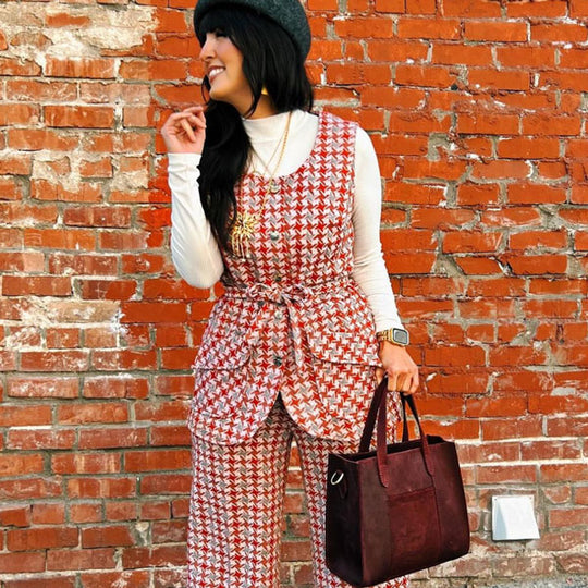 A person in a colorful outfit holding on to a Lola Crossbody Tote
