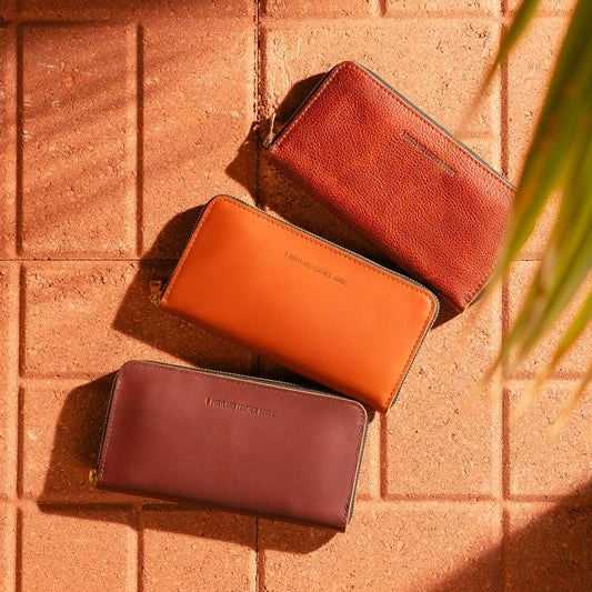 Three Accordion Zip Wallets on a textured surface.