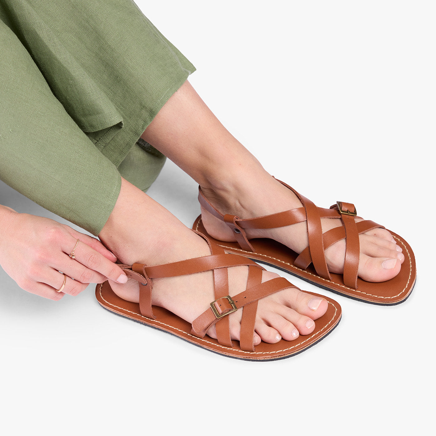 Miele | Person wearing strappy leather sandals with two buckle accents
