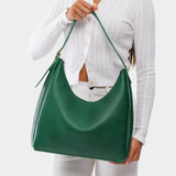 Bacalar Large | Model holding u-shaped, flat-bottomed leather shoulder bag with adjustable strap