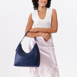 Cobalt Large | Model holding u-shaped, flat-bottomed leather shoulder bag with adjustable strap