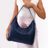 Cobalt Large | Model holding u-shaped, flat-bottomed leather shoulder bag with adjustable strap