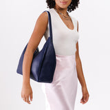 Cobalt Large | Model holding u-shaped, flat-bottomed leather shoulder bag with adjustable strap