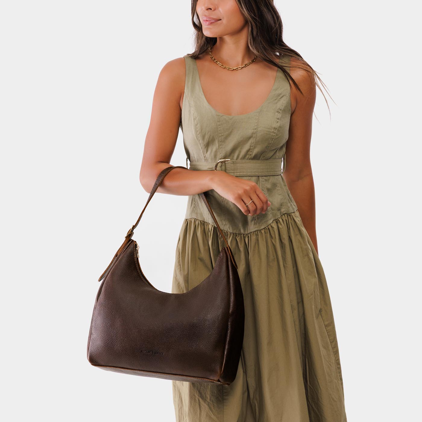 Coldbrew*Large | Model holding u-shaped, flat-bottomed leather shoulder bag with adjustable strap
