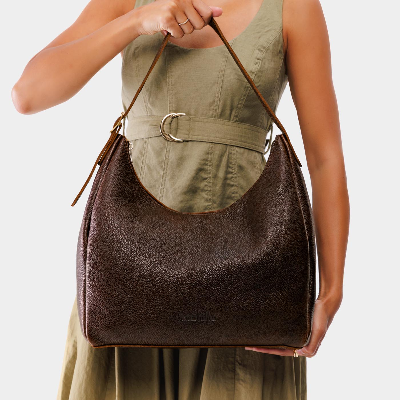 Coldbrew*Large | Model holding u-shaped, flat-bottomed leather shoulder bag with adjustable strap