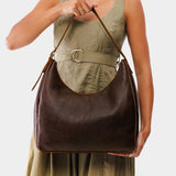 Coldbrew Large | Model holding u-shaped, flat-bottomed leather shoulder bag with adjustable strap