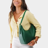 Bacalar Medium | Model holding u-shaped, flat-bottomed leather shoulder bag with adjustable strap