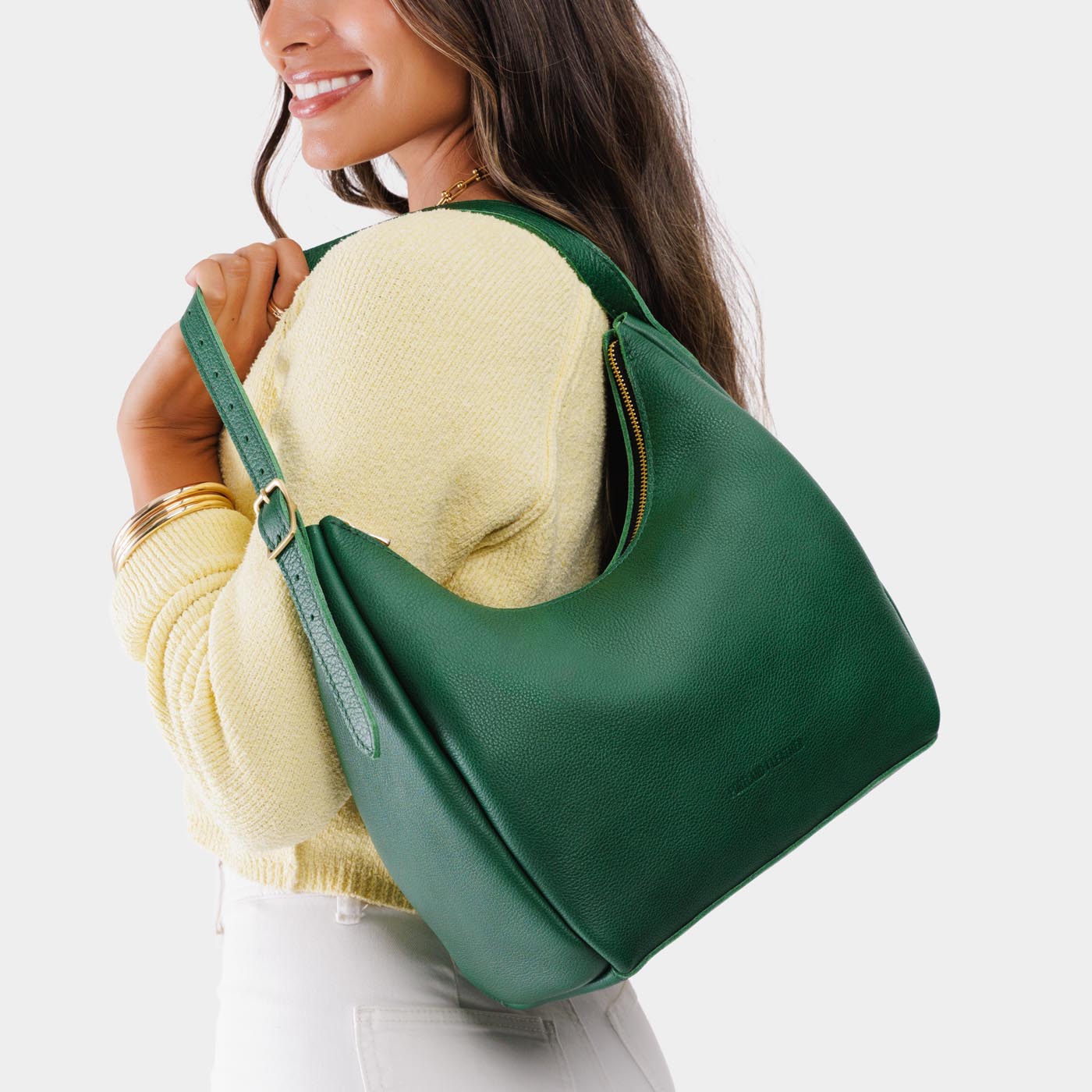 Bacalar*Medium | Model holding u-shaped, flat-bottomed leather shoulder bag with adjustable strap