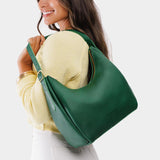 Bacalar Medium | Model holding u-shaped, flat-bottomed leather shoulder bag with adjustable strap