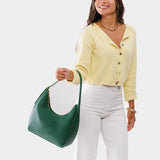Bacalar Medium | Model holding u-shaped, flat-bottomed leather shoulder bag with adjustable strap
