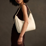 Pebbled Bone Medium | U-shaped, flat-bottomed leather shoulder bag with adjustable strap