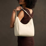 Pebbled Bone Medium | U-shaped, flat-bottomed leather shoulder bag with adjustable strap