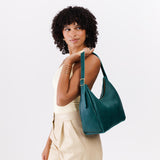 Sea Glass Medium | Model holding u-shaped, flat-bottomed leather shoulder bag with adjustable strap