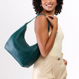 Sea Glass Medium | Model holding u-shaped, flat-bottomed leather shoulder bag with adjustable strap