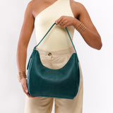 Sea Glass Medium | Model holding u-shaped, flat-bottomed leather shoulder bag with adjustable strap