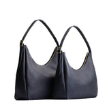 Night Owl | Size comparison image of large and medium u-shaped, flat-bottomed leather shoulder bags with adjustable strap