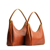 Sienna | Size comparison image of large and medium u-shaped, flat-bottomed leather shoulder bags with adjustable strap