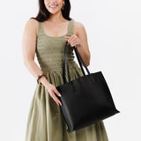 Black Large | Model holding leather tote bag with interior snap key loop