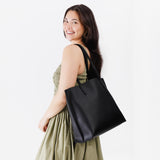 Black Large | Model holding leather tote bag with interior snap key loop
