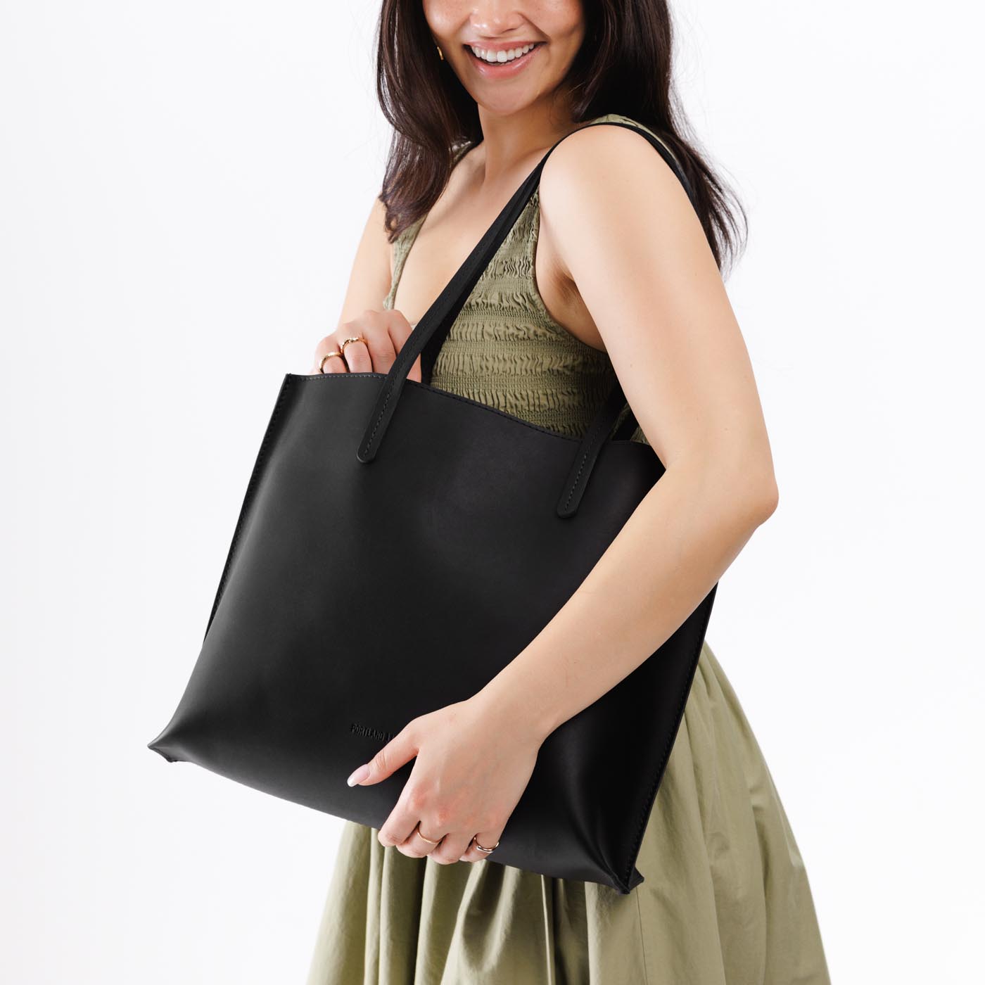 Black*Large | Model holding leather tote bag with interior snap key loop