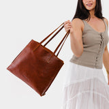 Nutmeg Large | Model holding leather tote bag with interior snap key loop