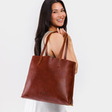 Nutmeg Large | Model holding leather tote bag with interior snap key loop