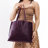 Plum Large | Model holding leather tote bag with interior snap key loop