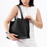Black Medium | Model holding leather tote bag with interior snap key loop