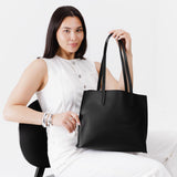 Black Medium | Model holding leather tote bag with interior snap key loop