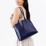 Cobalt Medium | Model holding leather tote bag with interior snap key loop