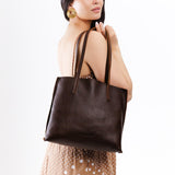 Coldbrew Medium | Model holding leather tote bag with interior snap key loop